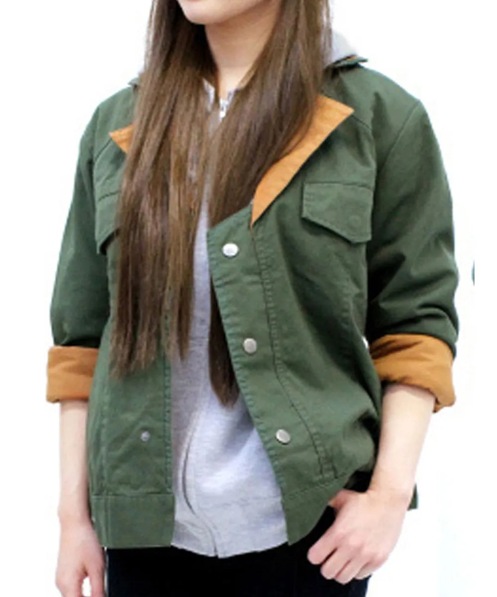 A woman wearing an olive green utility jacket with contrasting tan collar and cuff lining, layered over a light gray top.